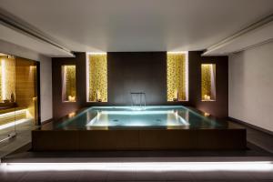 a jacuzzi tub in a room with windows at BoHo Prague Hotel - Small Luxury Hotels in Prague