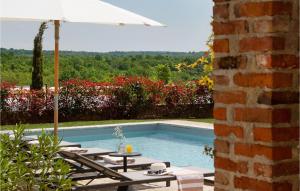 une piscine avec un parasol, une table et des chaises dans l'établissement Villa Adastra, à Sveti Lovreč Pazenatički 12 autres photos