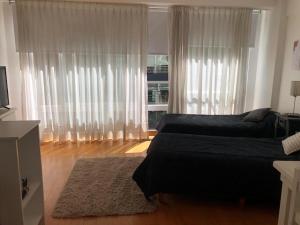 a bedroom with a bed and a window with curtains at Monoambiente en Cañitas in Buenos Aires