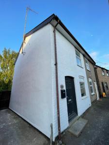 a large white building with a black door at Nice 2 bedroom house in Stowmarket in Stowmarket