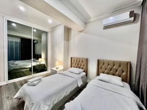 a bedroom with two beds and a mirror at Park Azure 2 bedroom apart in Xalxal
