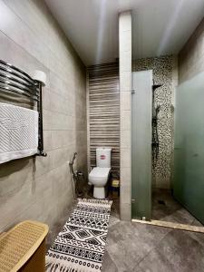 a bathroom with a toilet and a tiled floor at Park Azure 2 bedroom apart in Xalxal