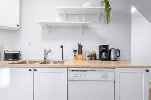 a kitchen with white cabinets and a sink at Charming 1-bed basement, Wi-Fi in Barrie +7 photos