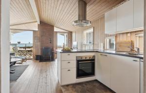 a kitchen with white cabinets and a stove top oven at Holiday Home Krokusvej in Egeskov