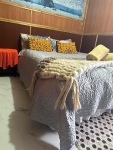 a bedroom with a bed with a blanket on it at MJ Patagonia in Puerto Natales