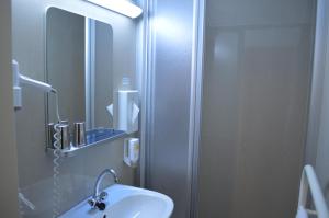 a bathroom with a sink and a mirror at Hotel Donaustadt Kagran in Vienna