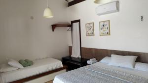 ein Schlafzimmer mit zwei Betten und einem Fenster in der Unterkunft Villa 06 - Taiba Beach Resort - TBR in São Gonçalo do Amarante + 72 Fotos