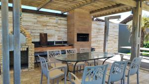 eine Terrasse mit einem Tisch, Stühlen und einem Kamin in der Unterkunft Villa 06 - Taiba Beach Resort - TBR in São Gonçalo do Amarante