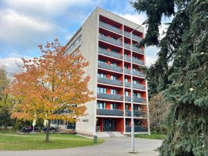 a tall building with a tree in front of it at Apartments 4u: KAMPUS Hradec Králové in Hradec Králové
