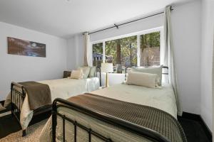 two beds in a room with a window at Dream Moon House - Great Location, Hot Tub, Game Room, Pool Table, Air Hockey, Foosball in Big Bear City +42 photos