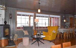 a living room with yellow chairs and a table at Cozy Home In Noresund With Kitchen in Noresund