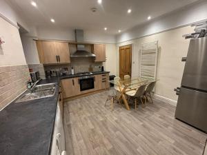 a large kitchen with a table and a refrigerator at The Brooklyn in Kendal