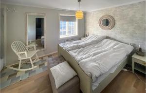 a bedroom with a bed and a chair and a mirror at 4 Bedroom Cozy Home In Svorkmo in Brattli +18 photos