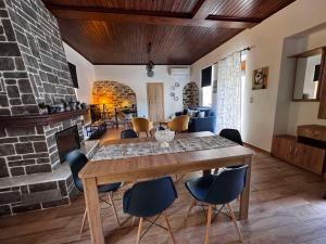 a living room with a wooden table and chairs at Land Of Olive in Kápsala