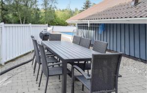 a wooden table and chairs on a patio at Nice Home In Knebel With Wifi in Ørby
