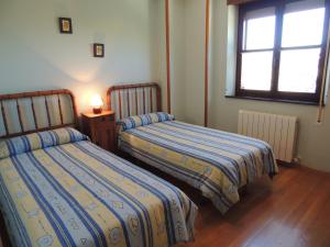 1 dormitorio con 2 camas y ventana en El Encinar, en Tarilonte