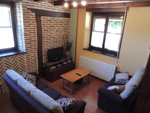 een woonkamer met 2 banken en een televisie bij El Encinar in Tarilonte