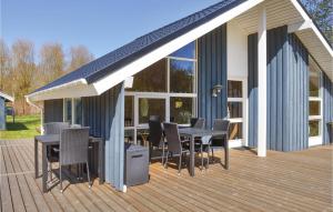 una terrazza con tavoli e sedie su una casa di Three-Bedroom Holiday Home In Strandby a Strandby