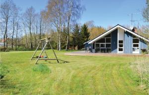 un parco giochi di fronte a una casa con altalena di Three-Bedroom Holiday Home In Strandby a Strandby Altre 9 foto