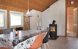 una sala da pranzo con tavolo e camino di Three-Bedroom Holiday Home In Strandby a Strandby