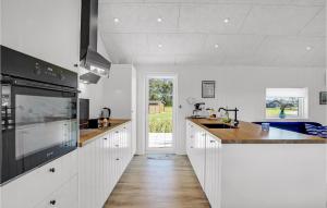 a kitchen with white cabinets and a counter top at Stunning Home In Hadsund With Five Bedrooms And Wifi in Hadsund