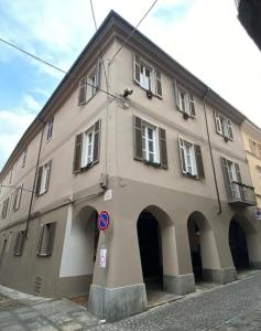 a large building with arches on a street at Casa La Bisbetica in San Damiano dʼAsti