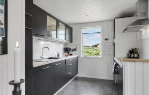 ロッケンにあるHoliday Home Lyngbygårdsvejのキッチン(グレーのキャビネット付)、窓