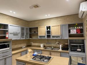 a kitchen with gray cabinets and a stove top oven at شقة الحياة 1 in Medina