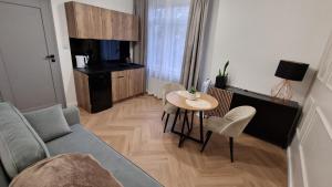 a living room with a couch and a table at Brama Lwowska Apartamenty - www-bramalwowska-pl in Zamość