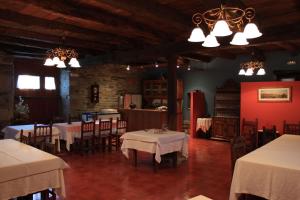 a dining room with tables and chairs and lights at Pazo Torre Do Barrio in Loseiro
