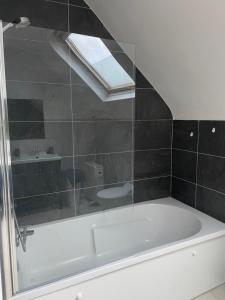 a bathroom with a bath tub and a sink at Le gîte de Myrlène-30min Parc Fédéral-12min CNPE CAUTION OBLIGATOIRE SWIKLY in Sully-sur-Loire +17 photos