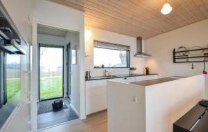 a kitchen with white cabinets and a large window at Four-Bedroom Holiday Home In Ebeltoft in Ebeltoft