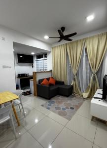 a living room with a couch and a ceiling fan at Amani Staycation Bandar Seri Alam#Studio in Masai
