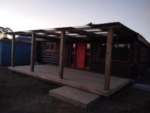 Cabaña de madera con techo en una cubierta en Casa troncos, en La Paloma