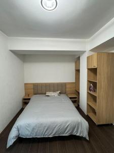 Un dormitorio con una cama grande y armarios de madera. en Cozy apartment with free parking, en Prilep 8 fotos más