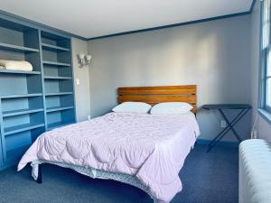 a bedroom with a bed with a wooden headboard at Cozy & Stylish Studio with Beautiful Lake Views & Fast Wifi in Watchung +12 photos