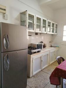 フェズにあるAppartement au centre-ville de Fèsのキッチン(ステンレス製の冷蔵庫、白いキャビネット付)