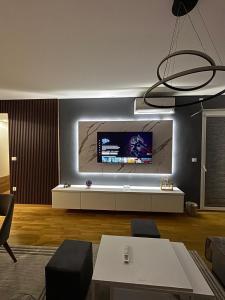 a living room with a flat screen tv on the wall at Luxury Apartment in Aerodrom in Skopje