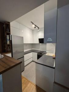 a kitchen with white cabinets and stainless steel appliances at Luxury Apartment in Aerodrom in Skopje +3 photos