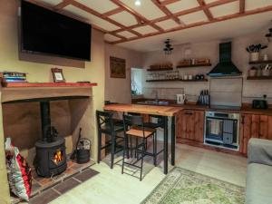 a kitchen with a stove and a bar with a fireplace at 1 Dinas cottages in Caernarfon