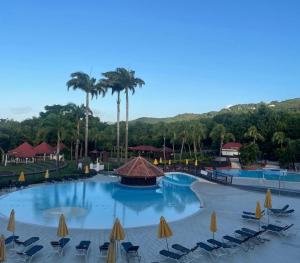 a large pool at a resort with chairs and umbrellas at Couleur Caraïbes- BARBADE appartement pierre et vacances accès plage et piscine in Sainte-Luce