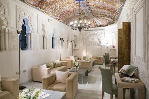 a lobby with chairs and tables and a ceiling at Hospes Palacio del Bailio, a Member of Design Hotels in Córdoba +73 photos
