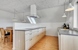 a kitchen with white cabinets and a sink and a table at Beautiful Apartment In Glesborg in Glesborg