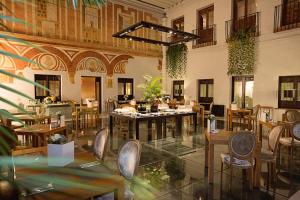 a restaurant with tables and chairs in a room at Hospes Palacio del Bailio, a Member of Design Hotels in Córdoba