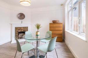 a dining room with a glass table and chairs at Astrid Room - Kingsize minimalist room in Luton in Luton