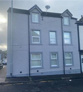 a gray building with white windows on a street at Spacious Property For Hols Base & Contractors Long or Short Stays C2C Western Lakes in Cleator Moor