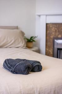 a towel sitting on top of a bed at Astrid Room - Kingsize minimalist room in Luton in Luton