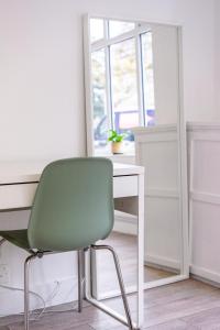 a green chair sitting in front of a desk at Astrid Room - Kingsize minimalist room in Luton in Luton