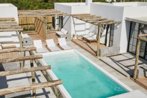 vistas a una piscina con sillas y a una casa en Casa Kai, en José Ignacio