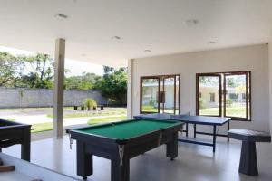 two pool tables in a room with windows at Casa aconchegante no Condomínio Reserva do Toque in São Miguel dos Milagres
